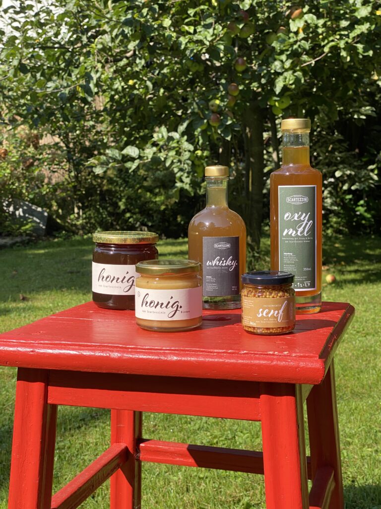 Produkte mit Honig von Scartezzinis Bienen auf rotem Stuhl